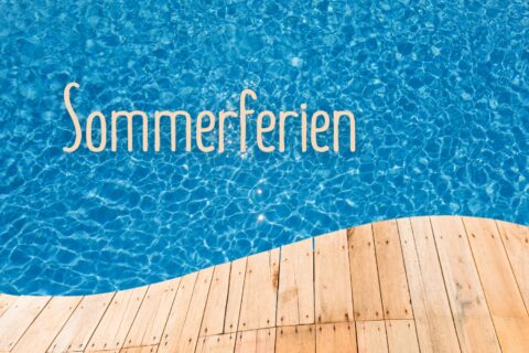 Schriftzug "Sommerferien" mit Poolwasser im Hintergrund und einer Holzliege.